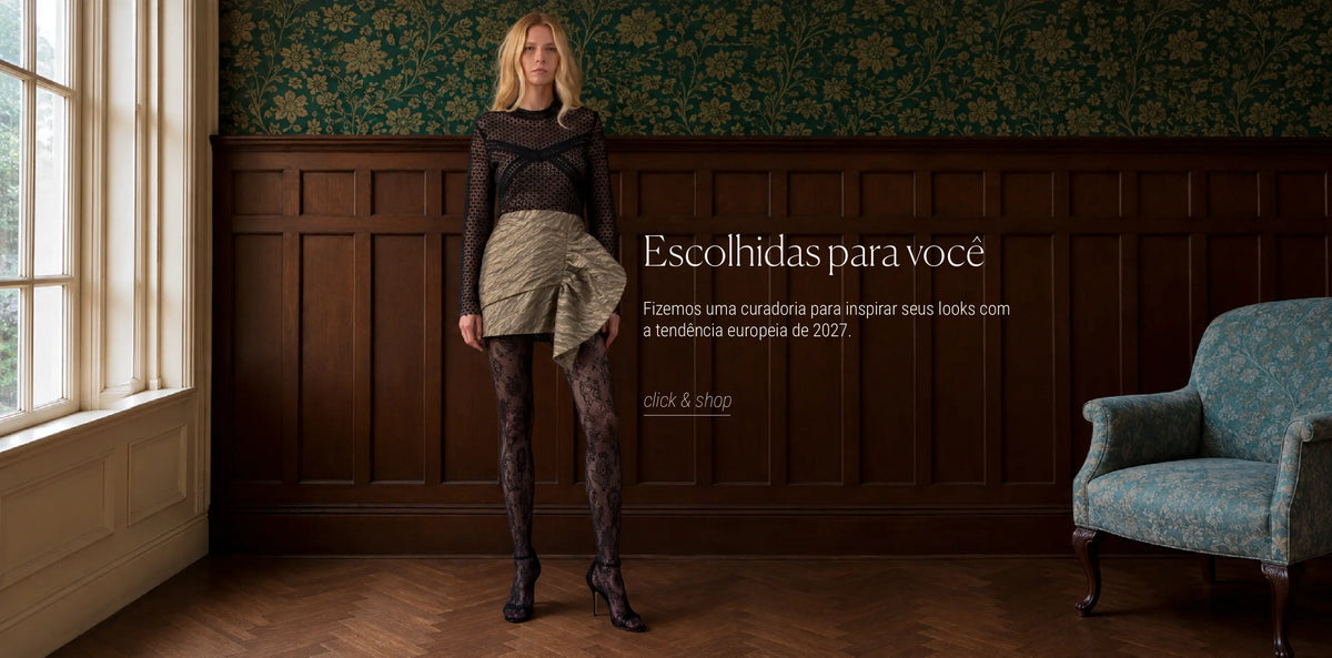 Escolhidas para você: curadoria para inspirar seus looks com a tendência europeia de 2027. Modelo com blusa de renda preta, saia drapeada e meia-calça rendada em sala com papel de parede verde